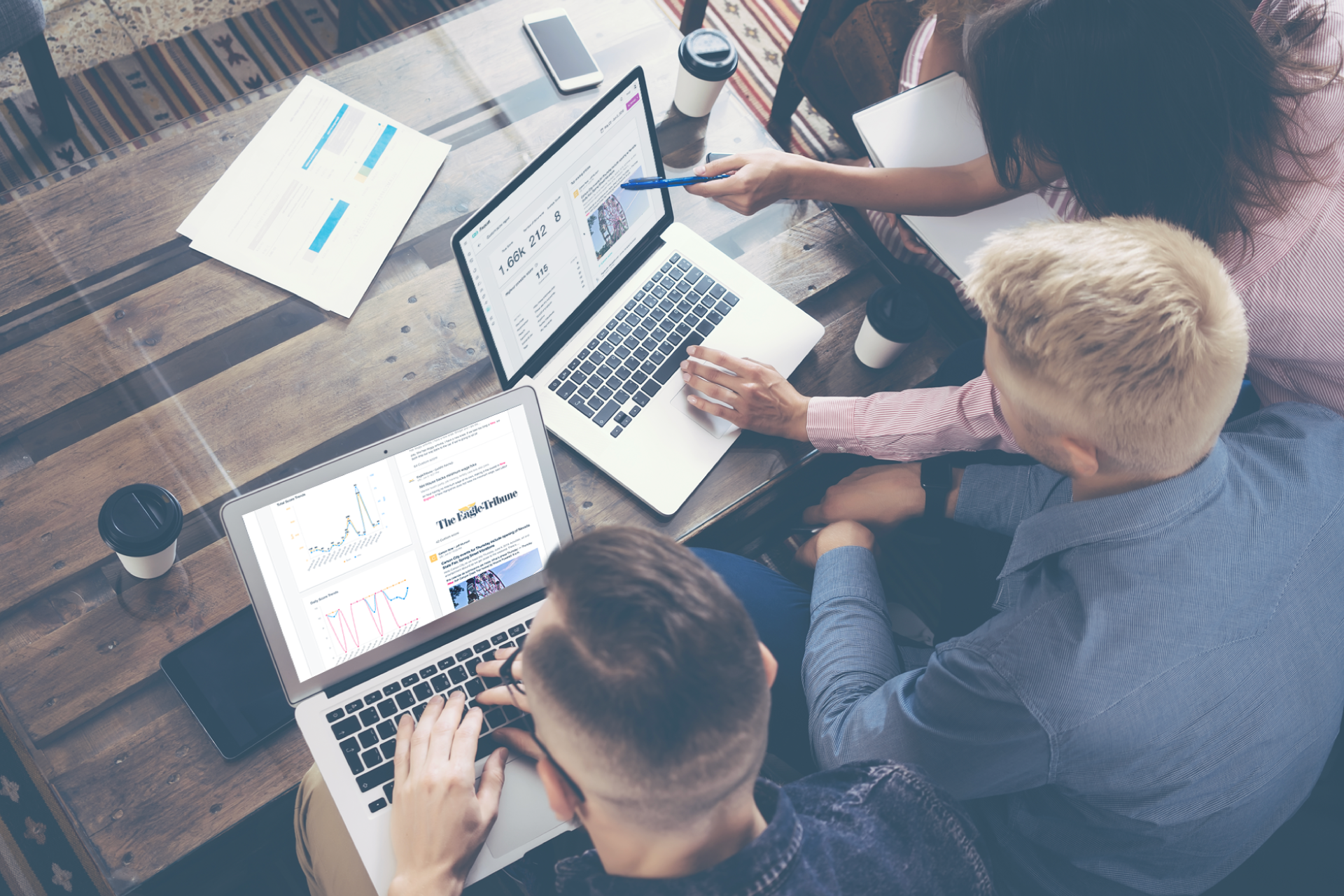 Photo from above of three people working together on their laptops