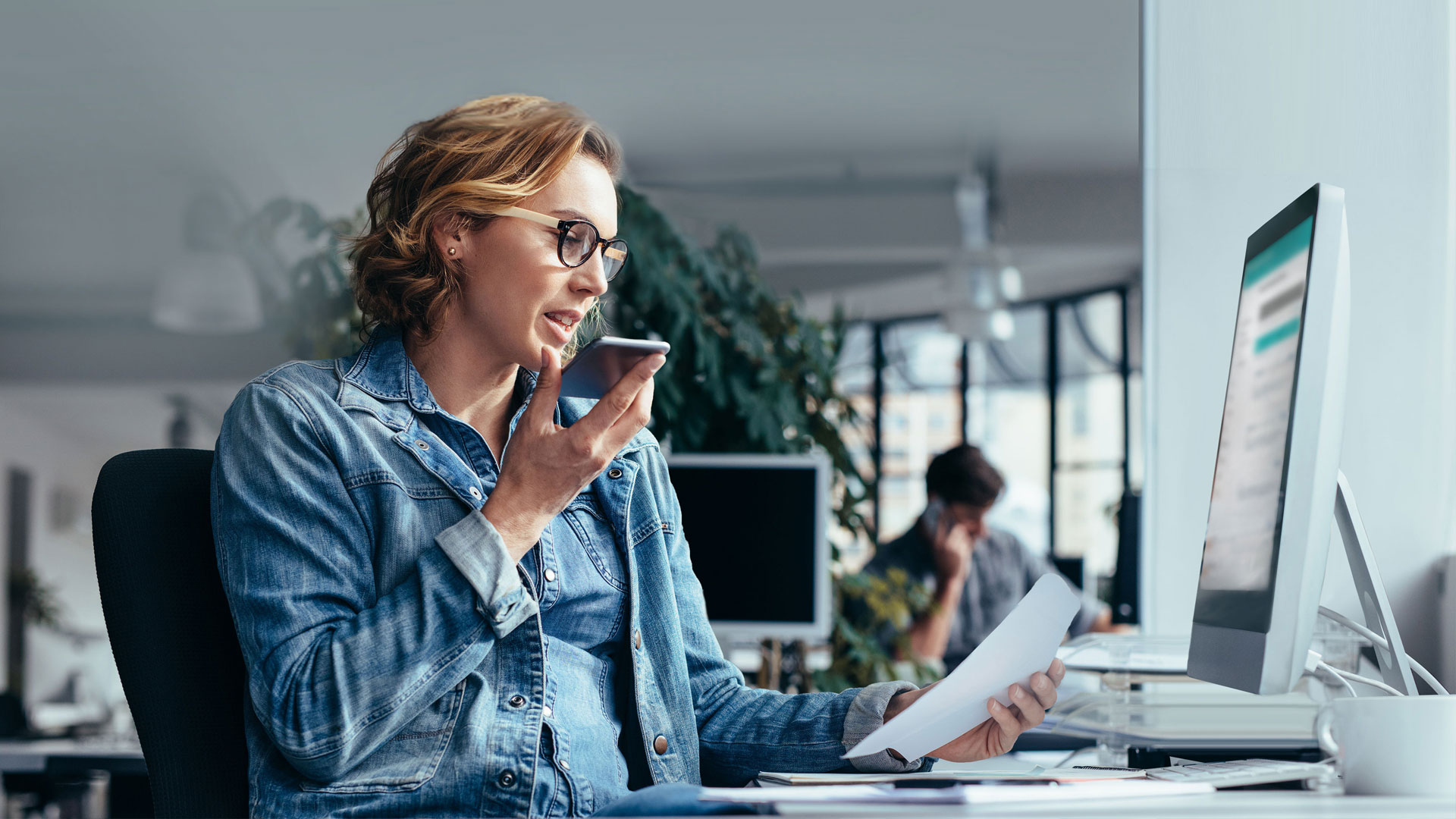 Photo of a woman sitting at her desk in the office having a call