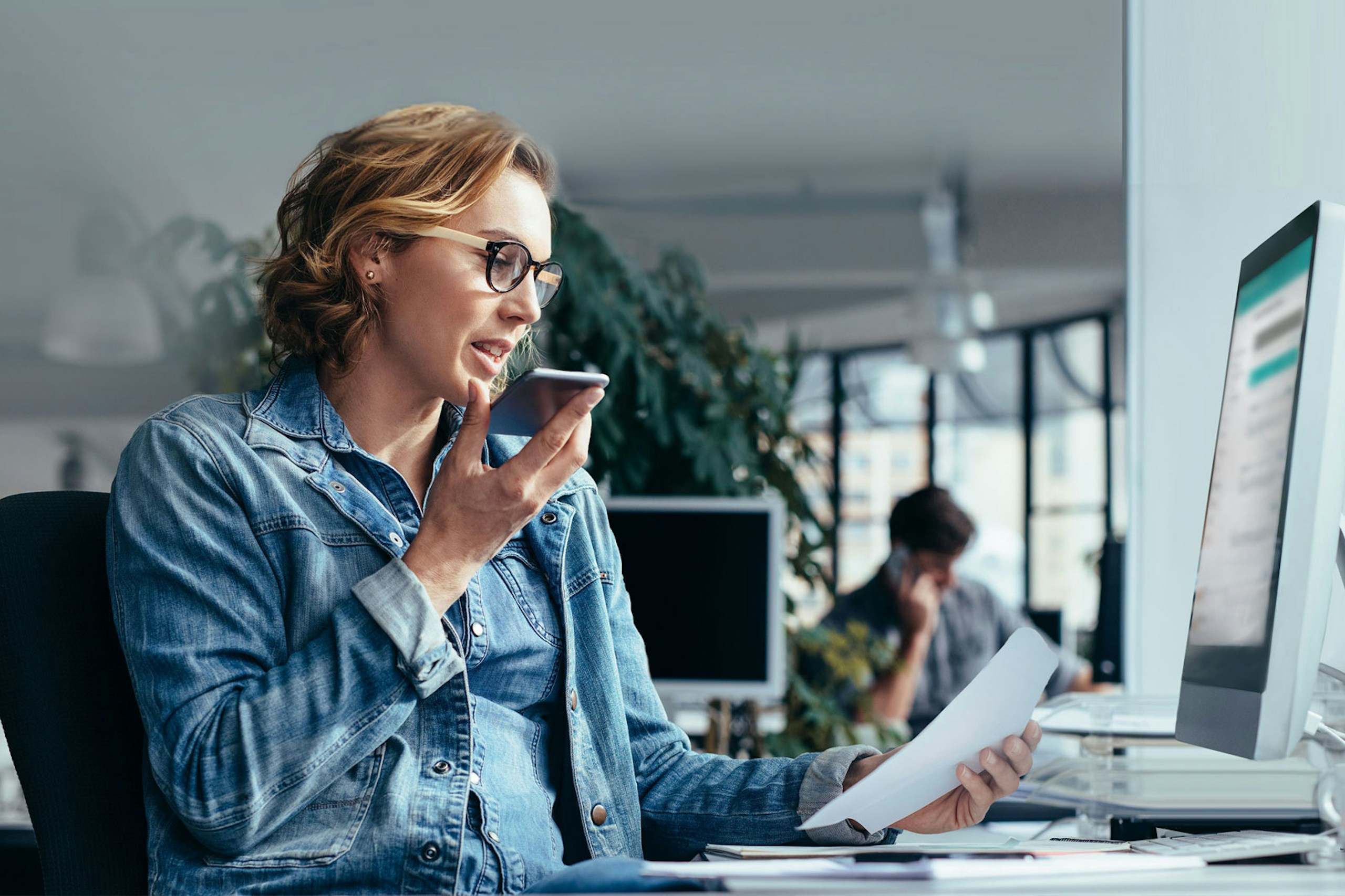 Photo of a woman sitting at her desk in the office having a call