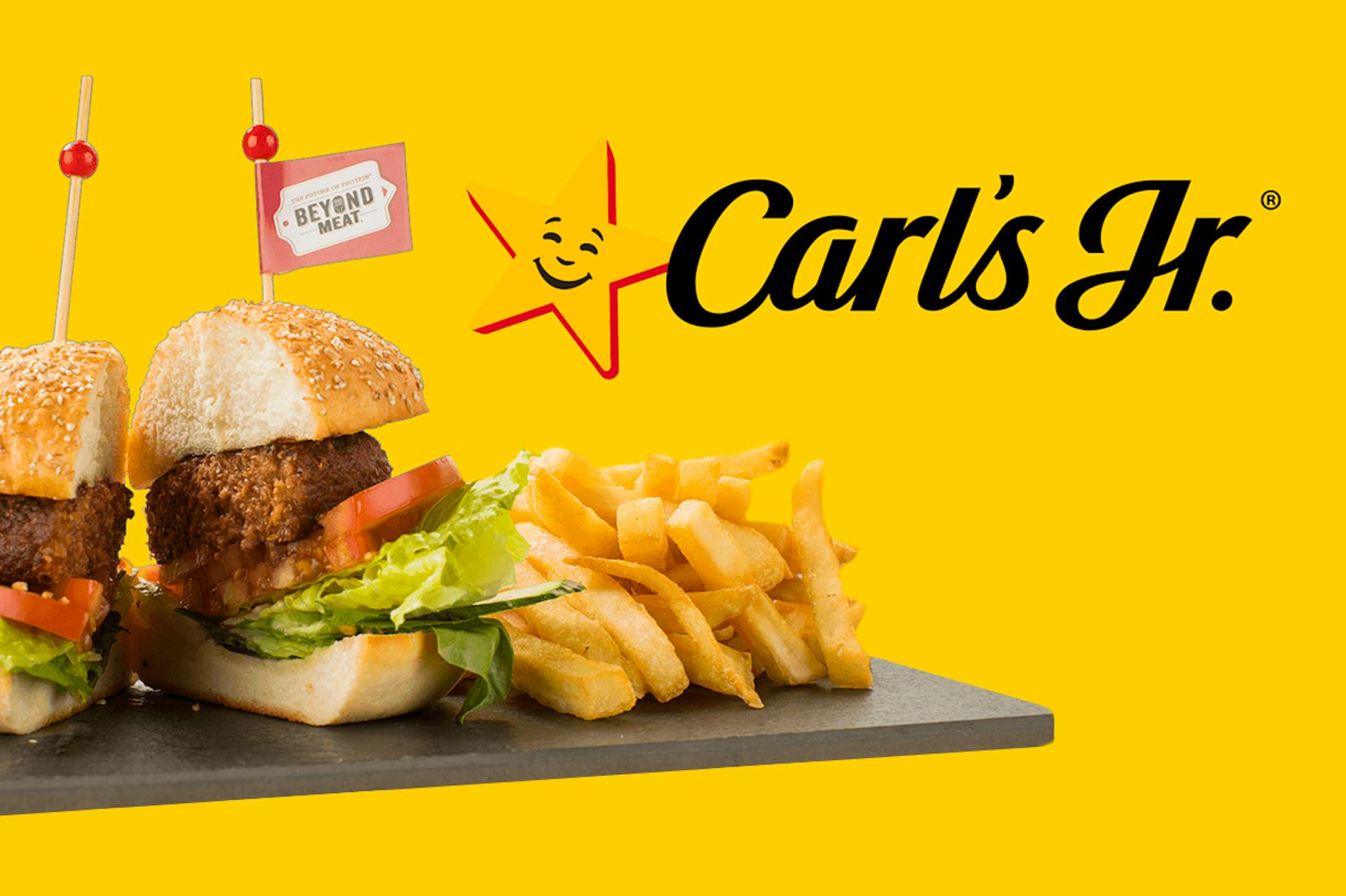 Fresh burger, cut in half, hot chips on a flat board. Carl's JR. logo o a yellow background. 