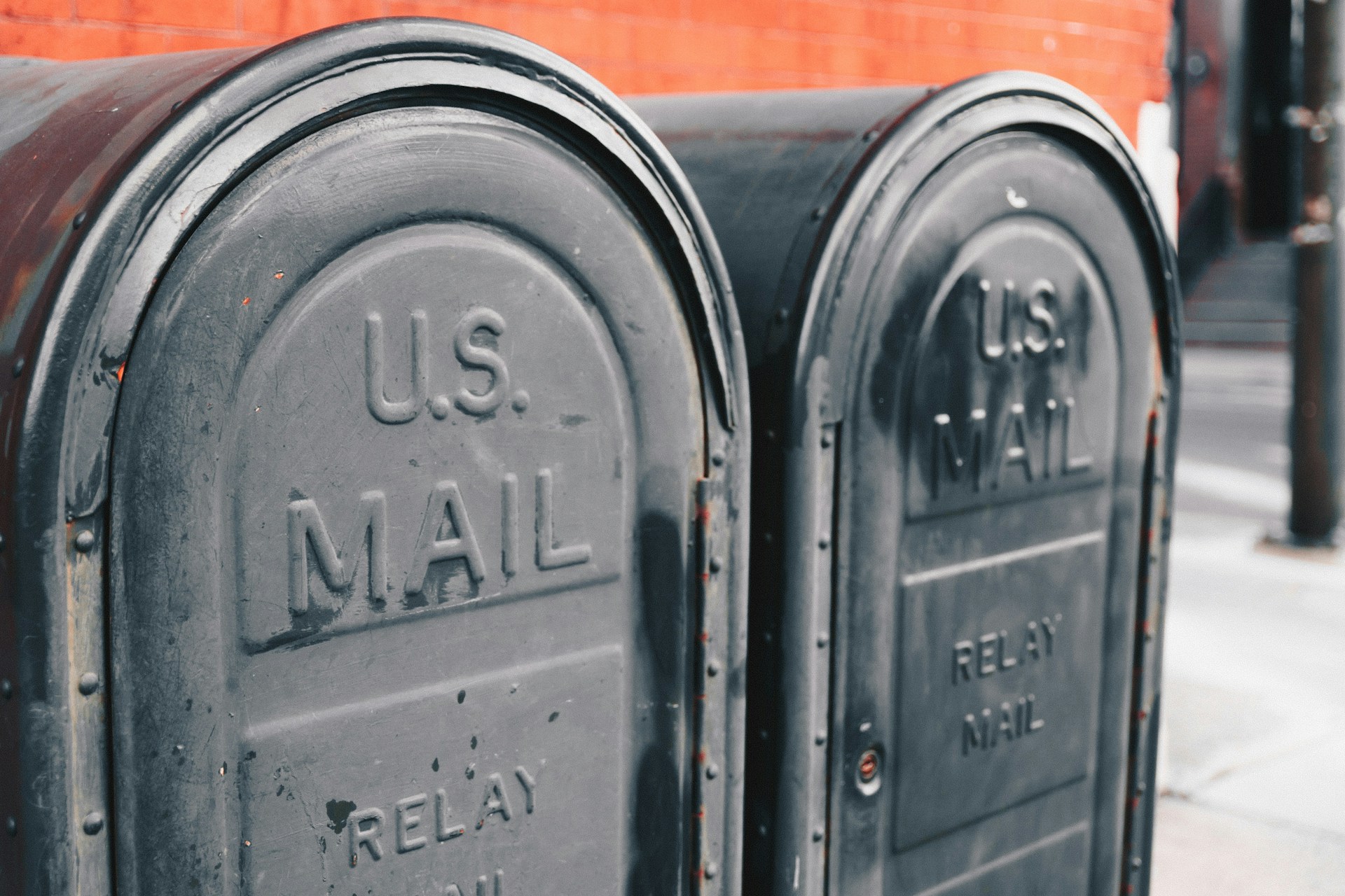 Two grey mail boxes on a city sidewalk. This image is being used as a thumbnail for a blog on direct marketing.