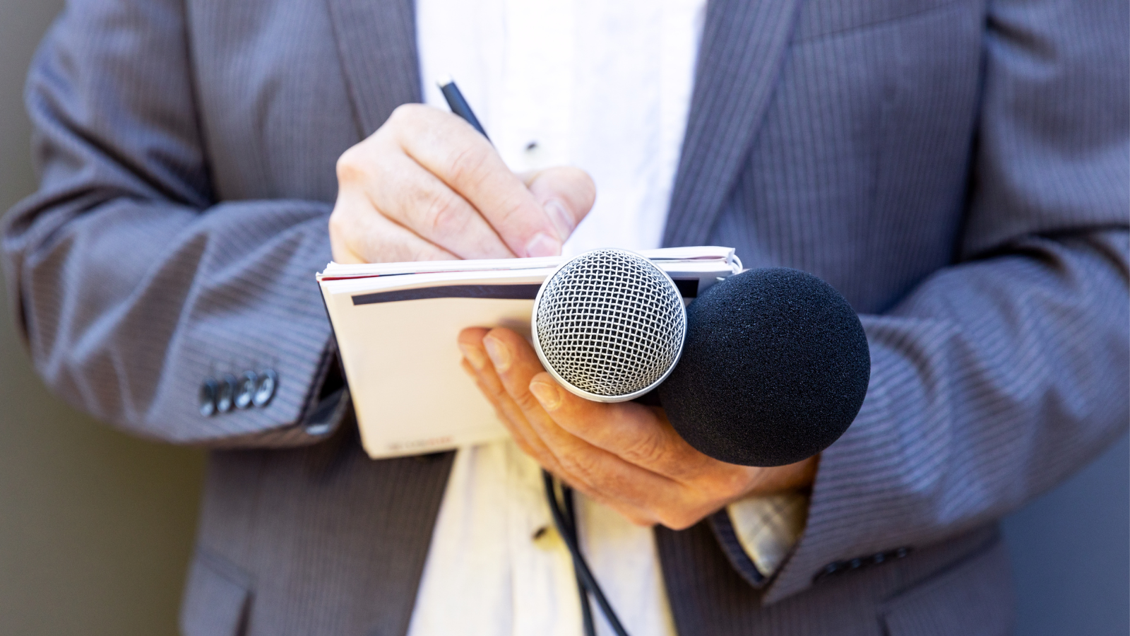 un attaché de presse qui écrit sur un bloc note 