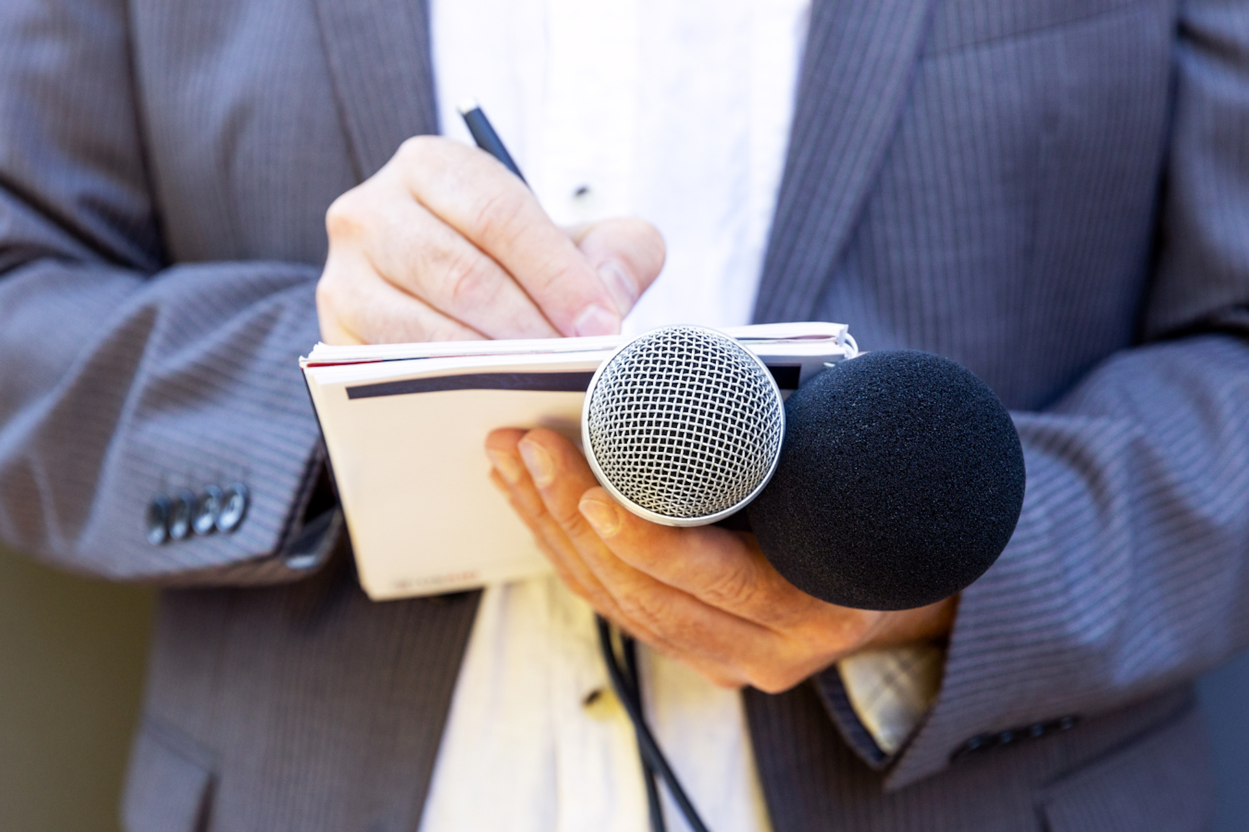 un attaché de presse qui écrit sur un bloc note