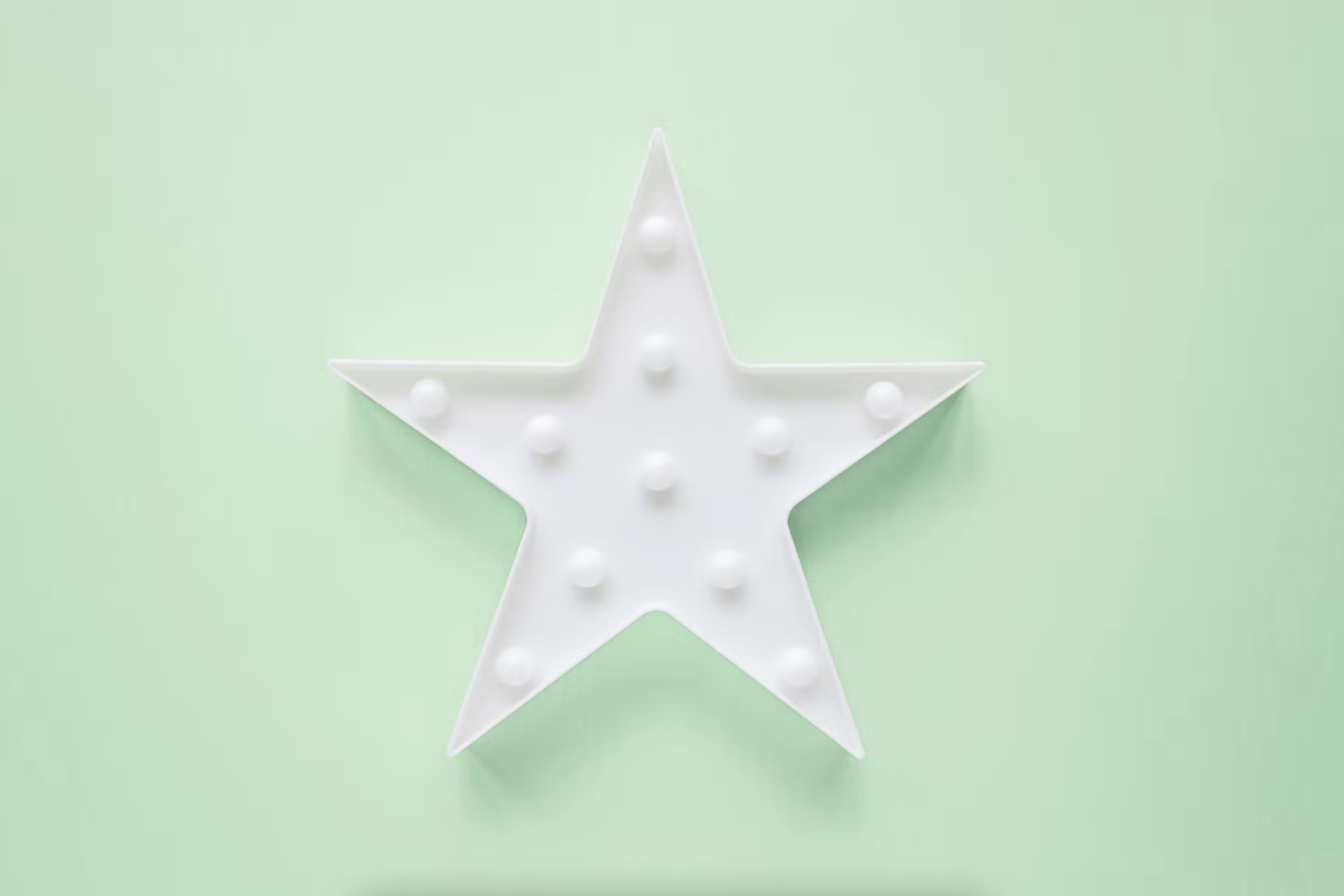 Ein weißer Stern vor einem hellgrünen minzfarbenen Hintergrund