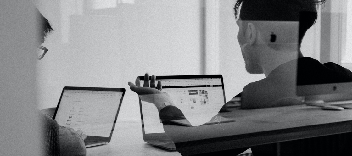 black and white photo of two people working on their laptops