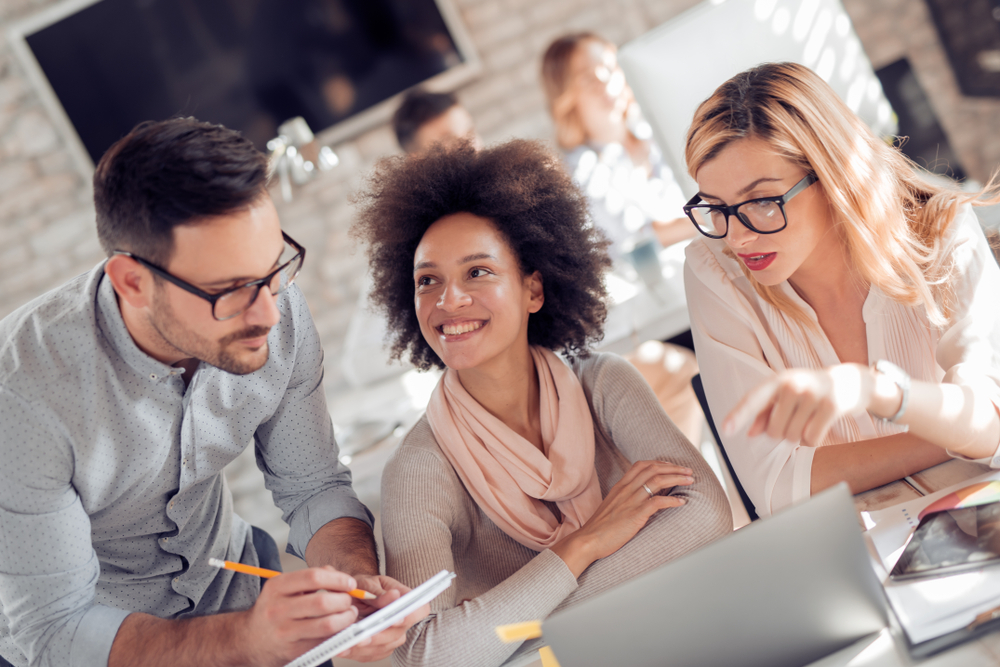 Arbeitskollegen besprechen etwas als Headerbild zu unserem Beitrag zu 4 Ps und 7 Ps im Marketing-Mix