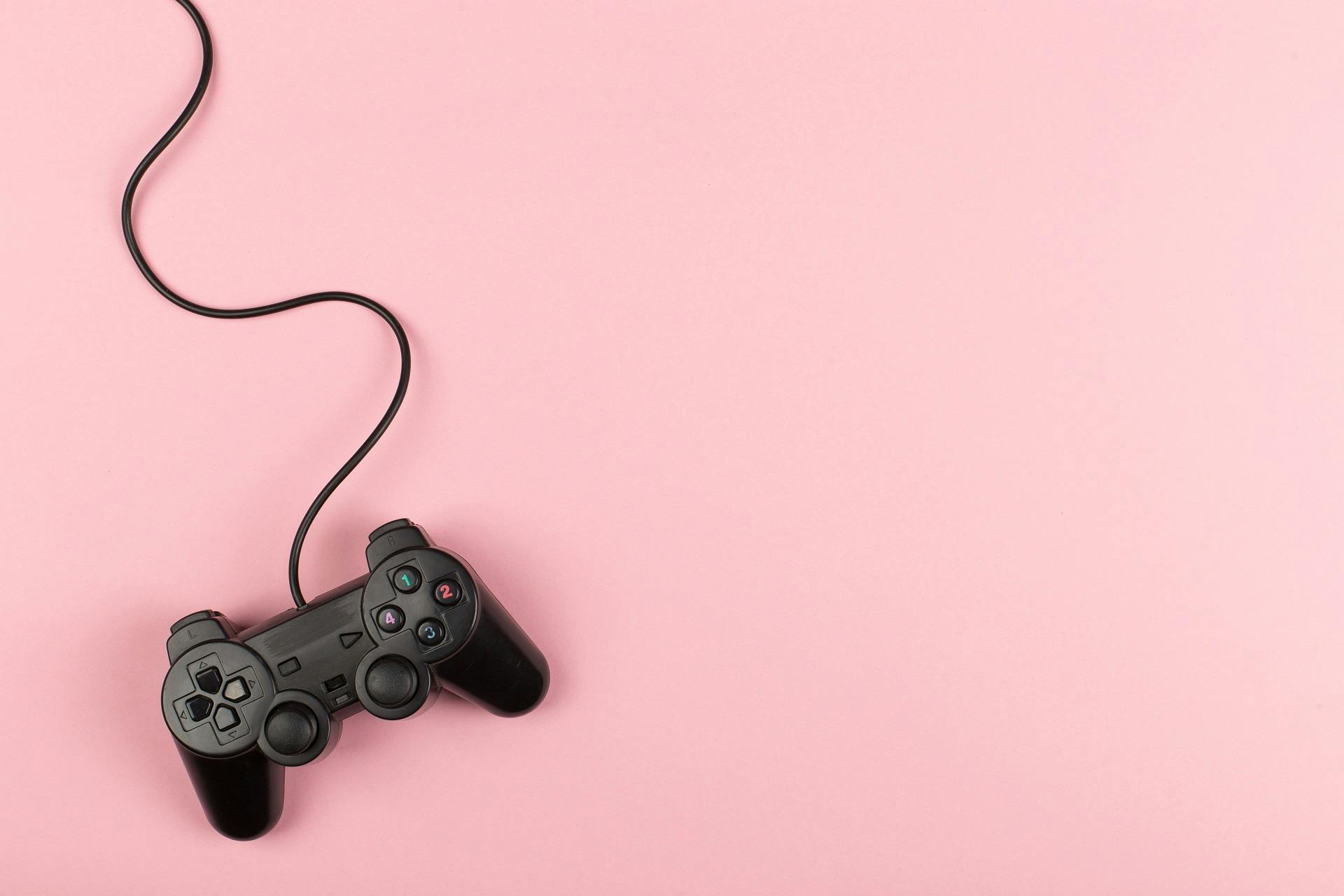 Picture of a game controller on pink background
