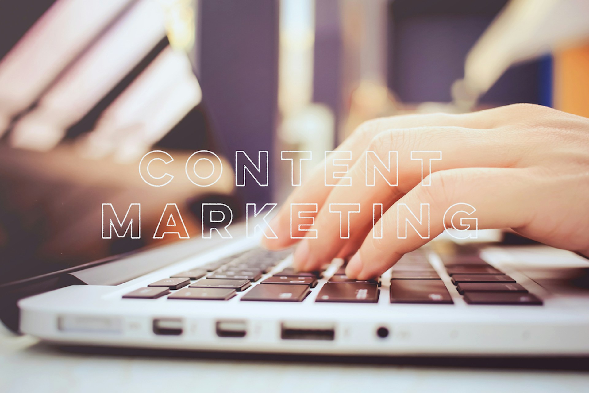 The title text "Content Marketing" overlaid over an image of a hand on a laptop keyboard