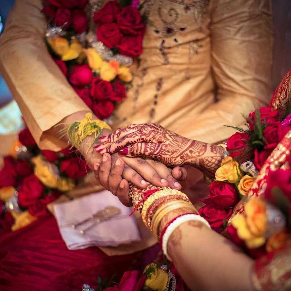 Groom and bride placing hand on each other for ritual pic