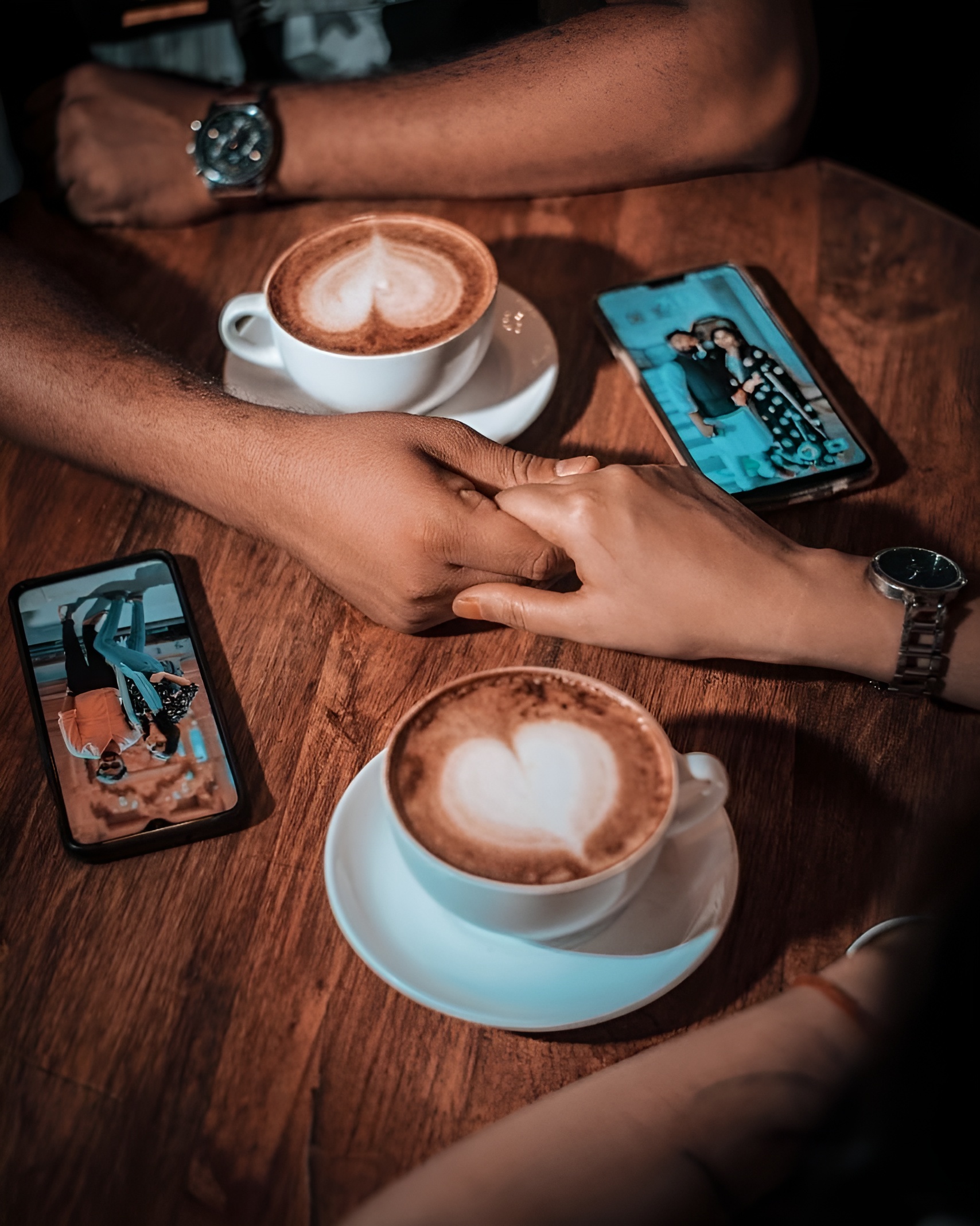 Holding hands beside cup of coffee pic