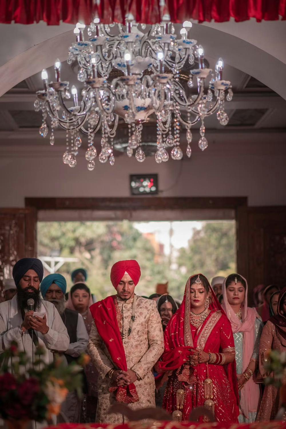 Couple taking wedding vows with family at Gurdwara