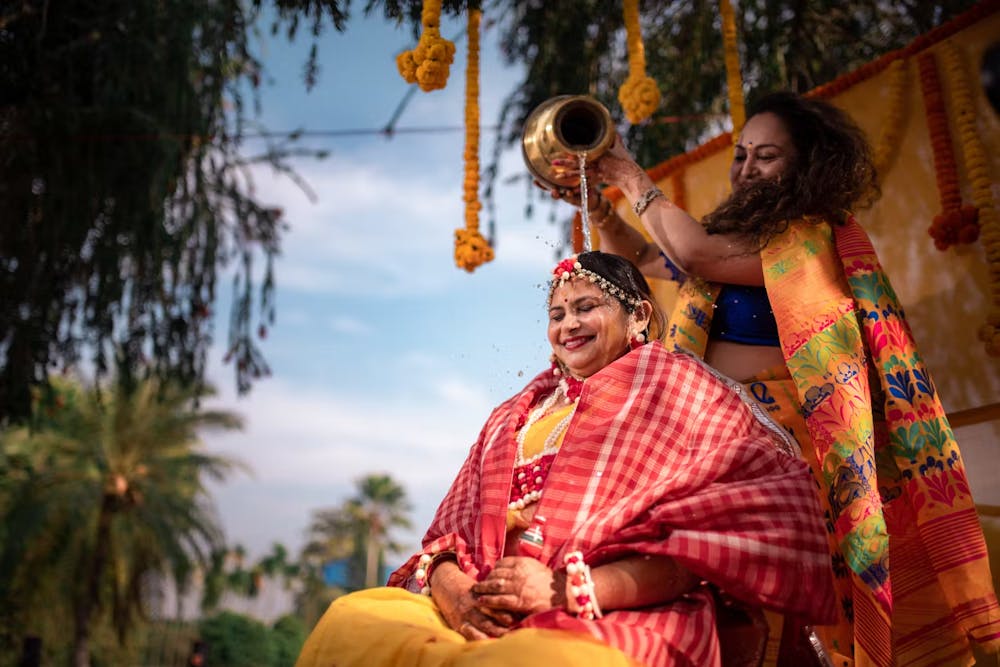 Mothering showering Haldi bride with water