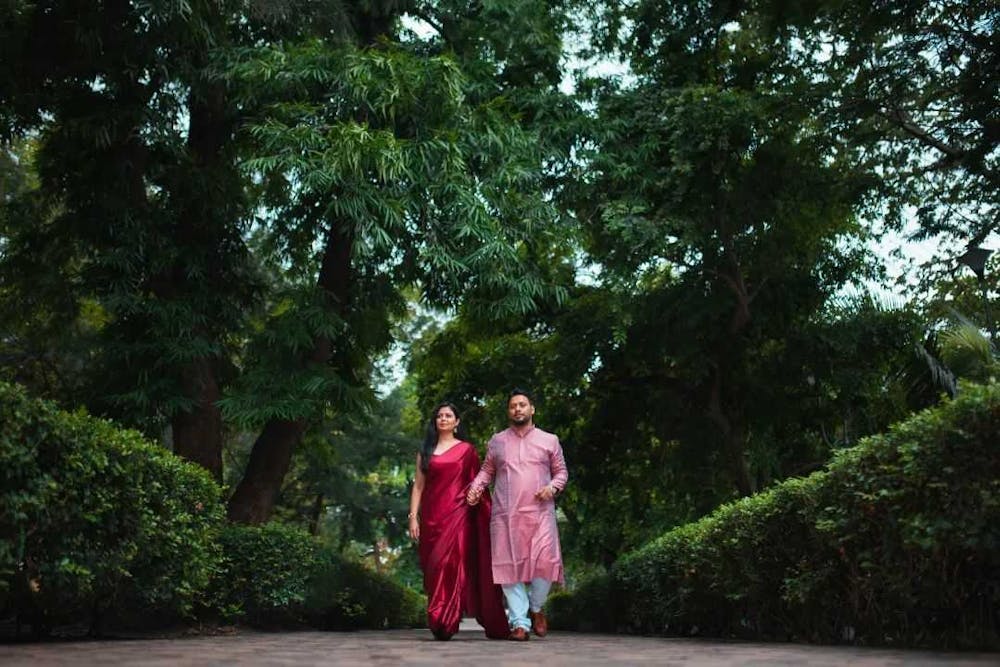 Couple walking while holding hands in green park pic