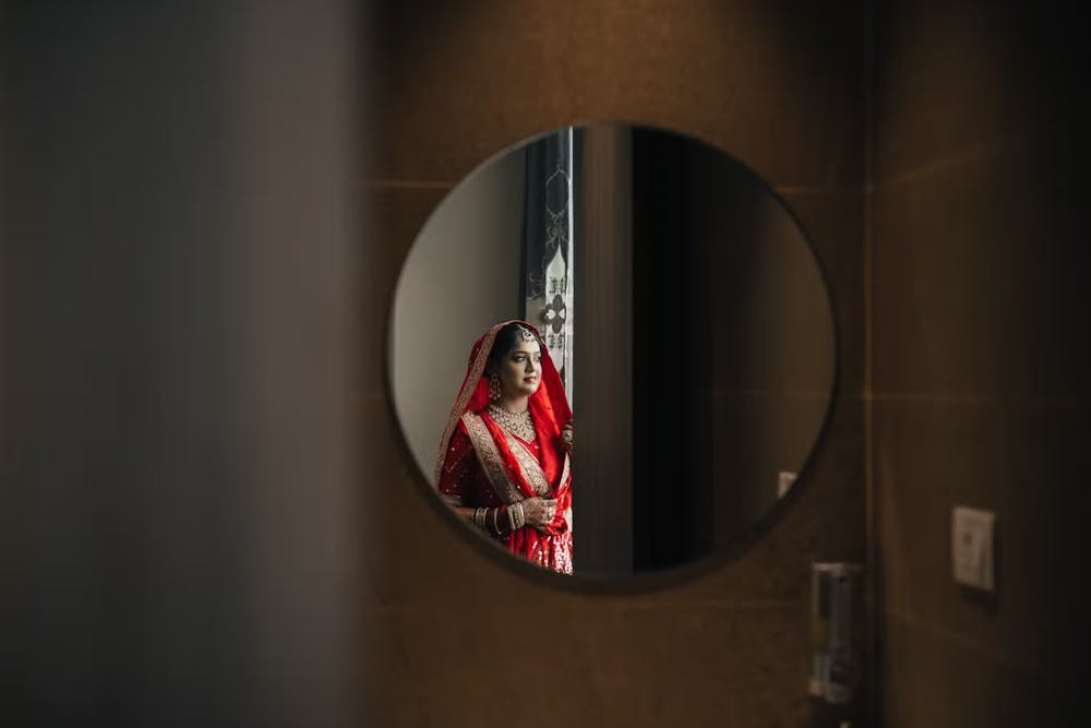 Bride posing against a mirror for wedding pics