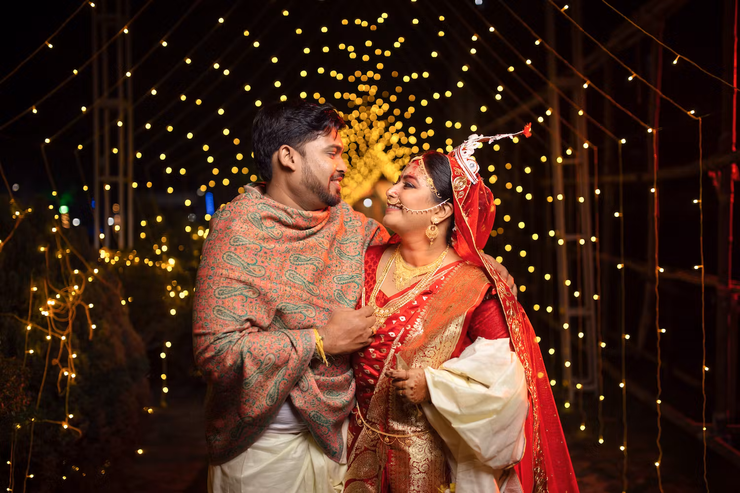 Groom posing romantically with wife wearing a shawl