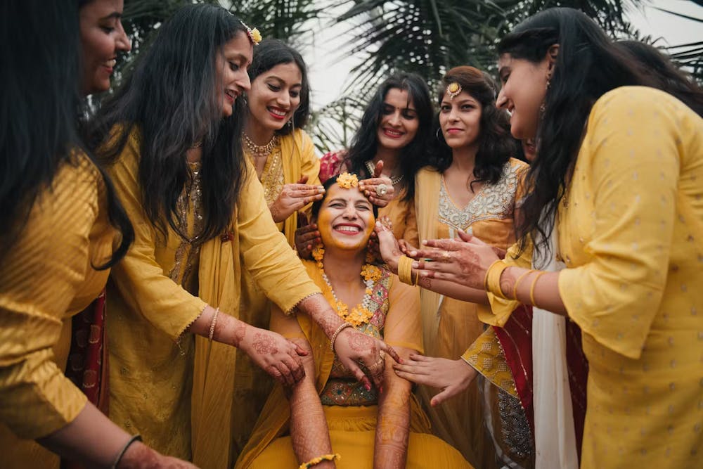 Friends applying Haldi on bride pic