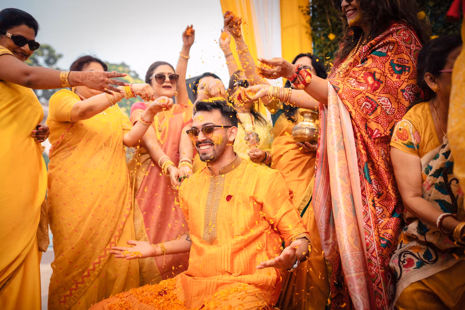 Relatives blessing a groom with flowers in his Haldi function picture