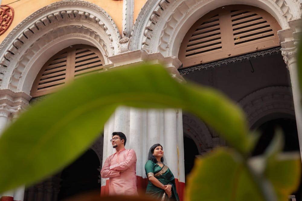 Young Bengali Couple at Serampore Rajbari posing near pillars, shot from under leaf