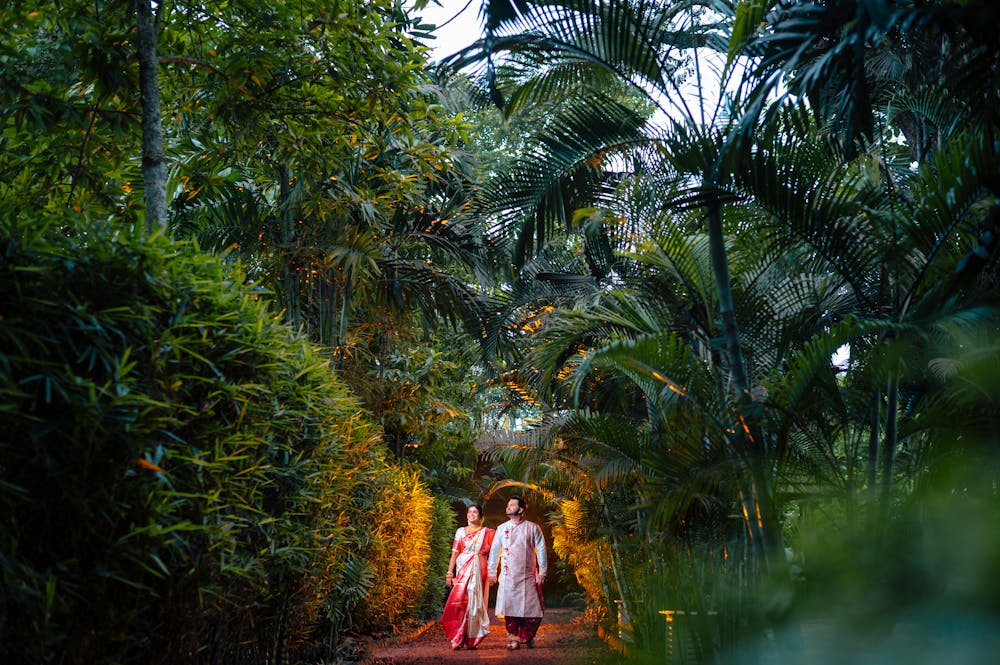 Bengali couple walking around nature during pre wedding photoshoot at Bawali Rajbari heritage location | Memories Designer