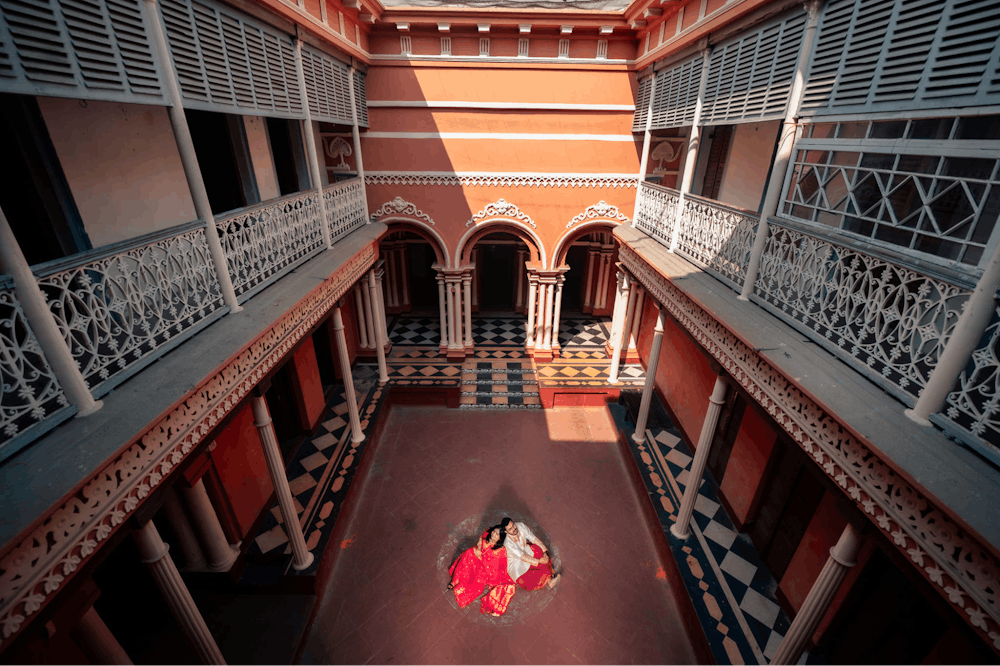 bengali couple sitting in the courtyard at North Kolkata Pre-Wedding Photoshoot | Memories Designer
