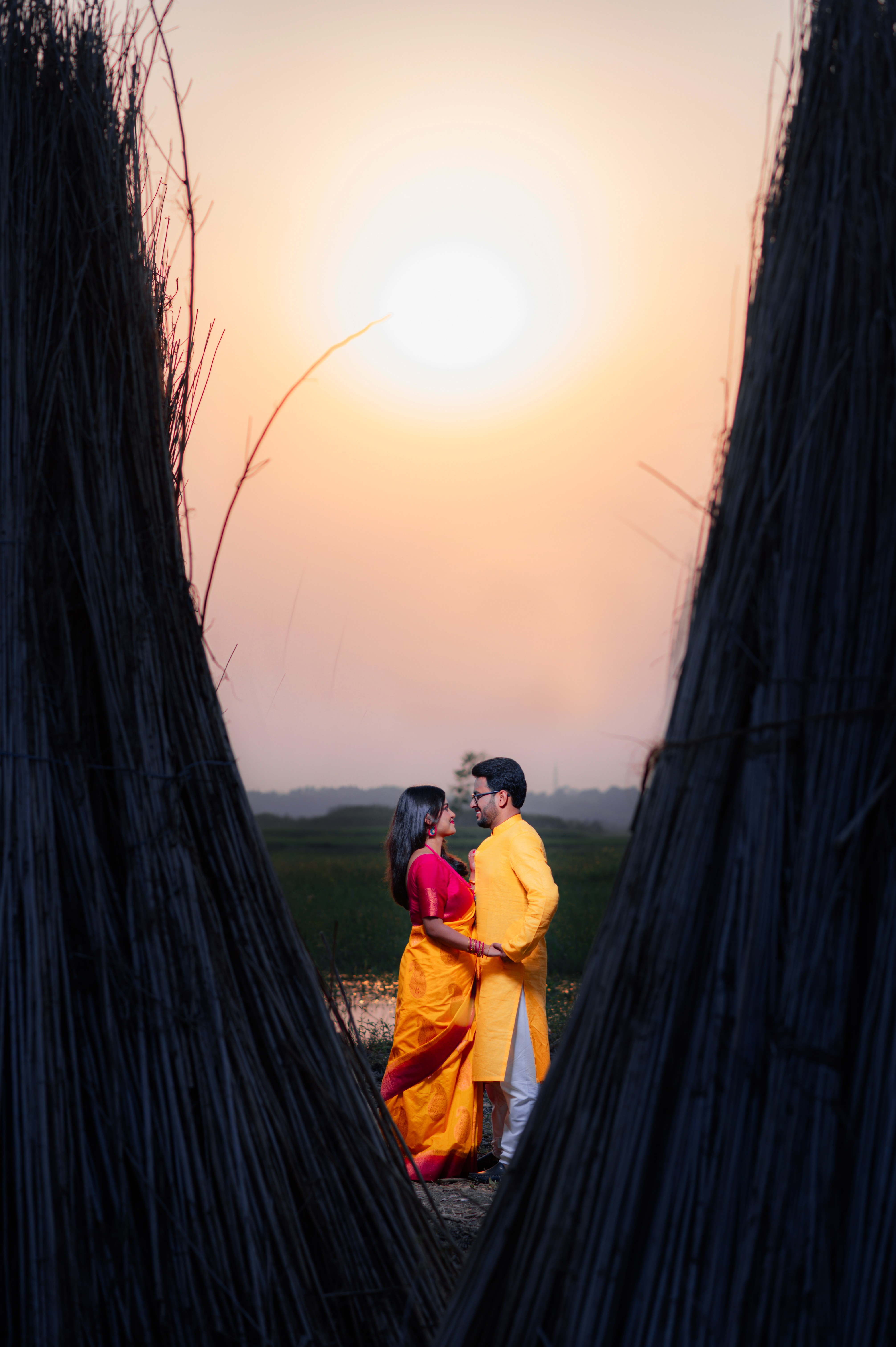 Bengali couple on the fields, holding each other for Pre-Wedding Photoshoot | Memories Designer