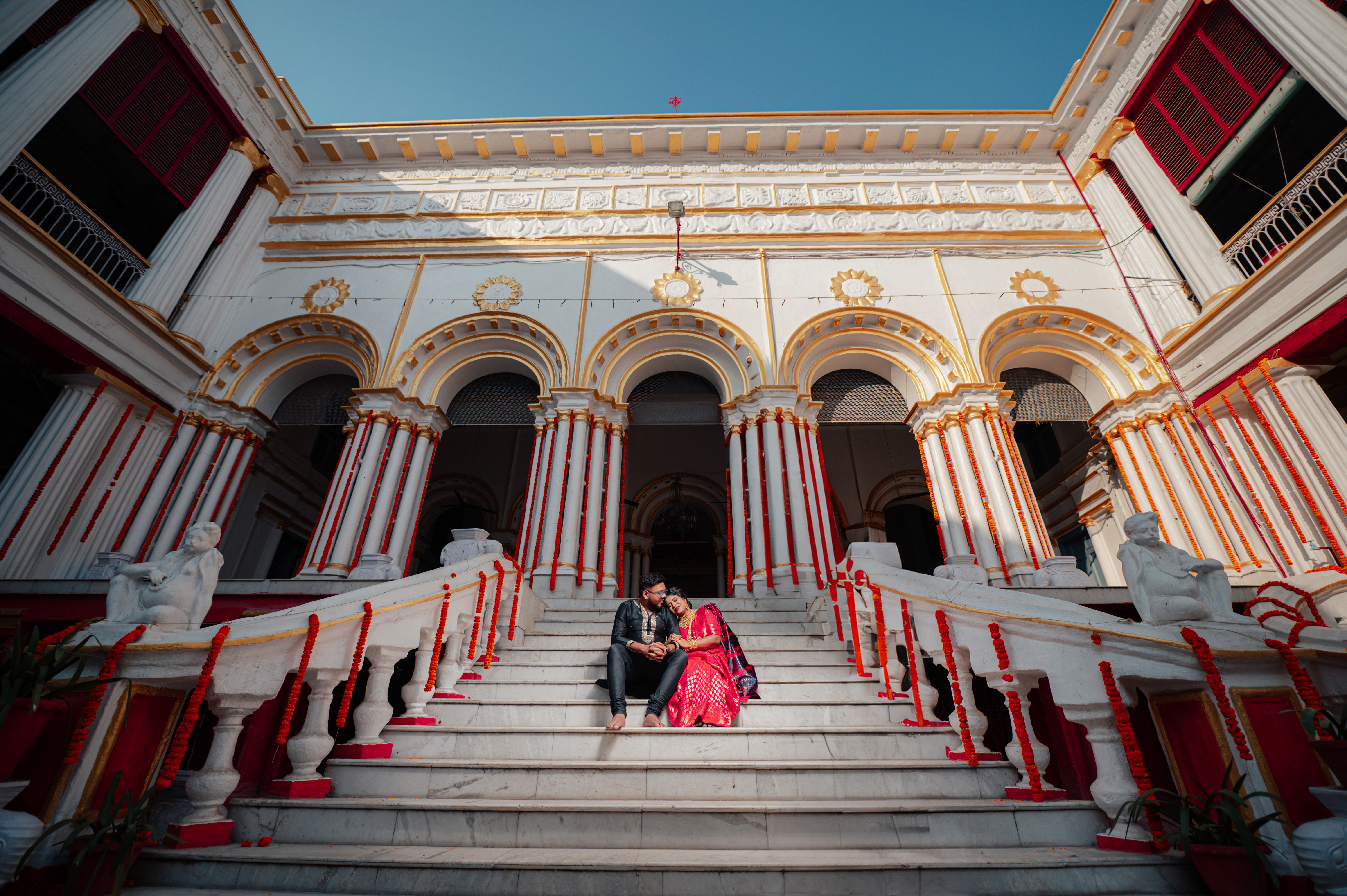 Bengali couple chatting on the stairs of Pathuriaghata Rajbari for Pre Wedding Photoshoot | Memories Designer