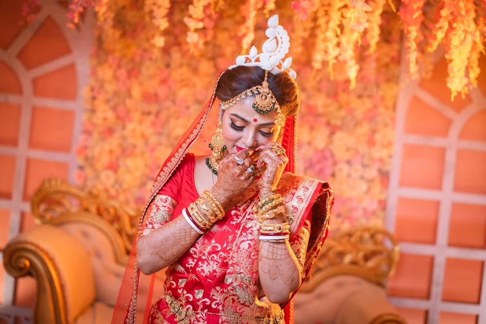 Bride fixing her traditional bridal nose ring at Bengali | Memories Designer