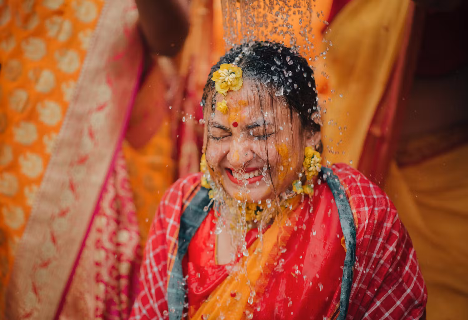 Funny wedding photography ideas for Indian bride at Haldi ceremony. Water splashed by family on the bride | Memories Designer