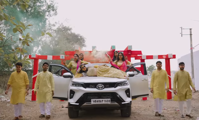 Funny wedding photography ideas where an Indian bride sleeps above the car with sunglasses | Memories Designer