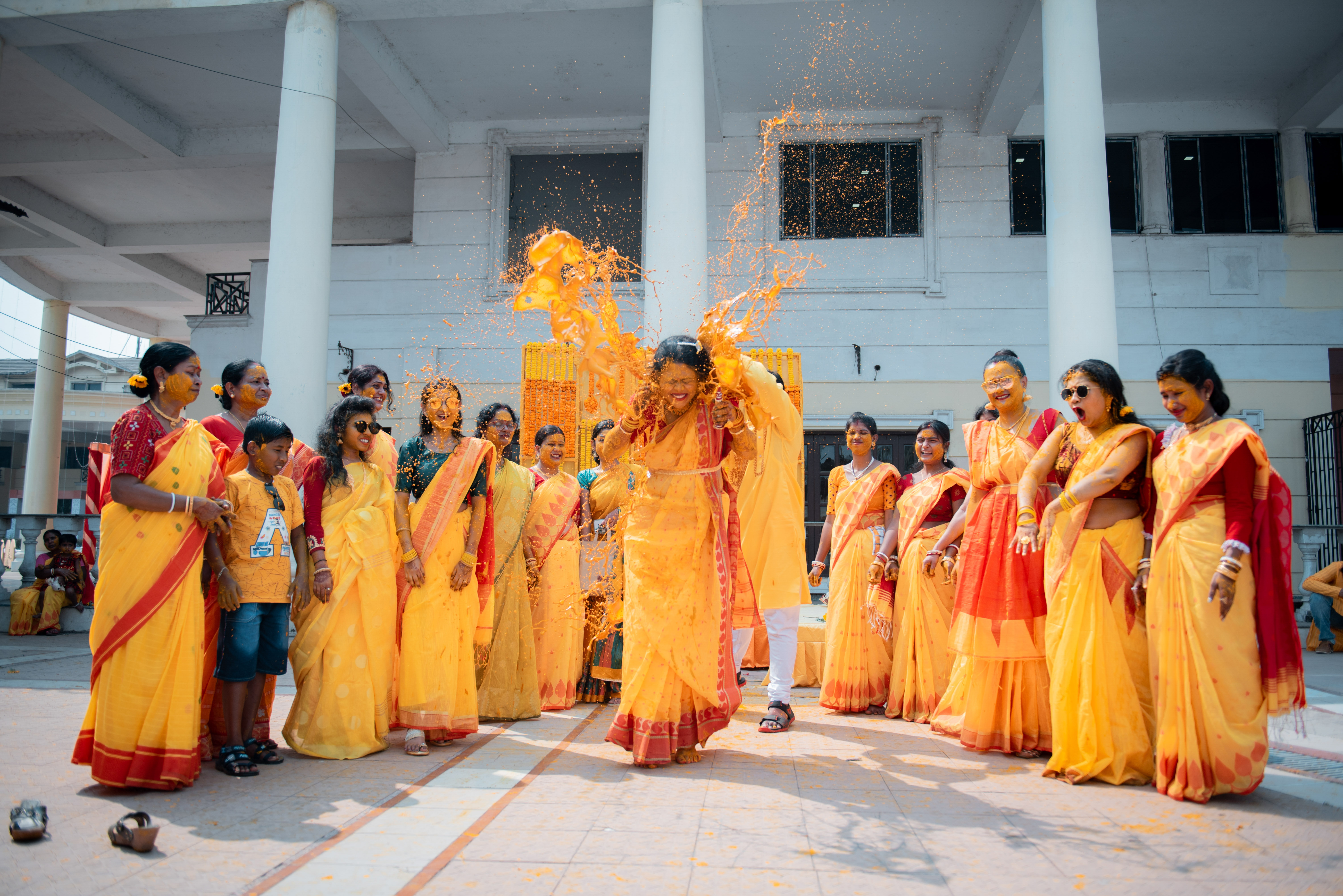 A colorful Haldi ritual with bride and bridesmaid