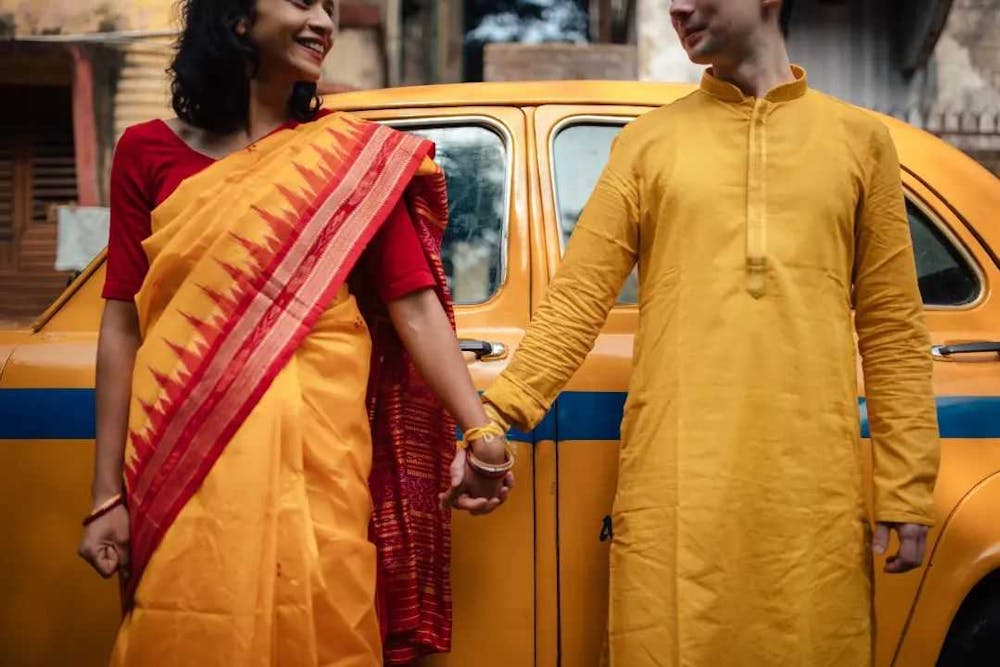 Couple posing in front of a yellow taxi in Kolkata