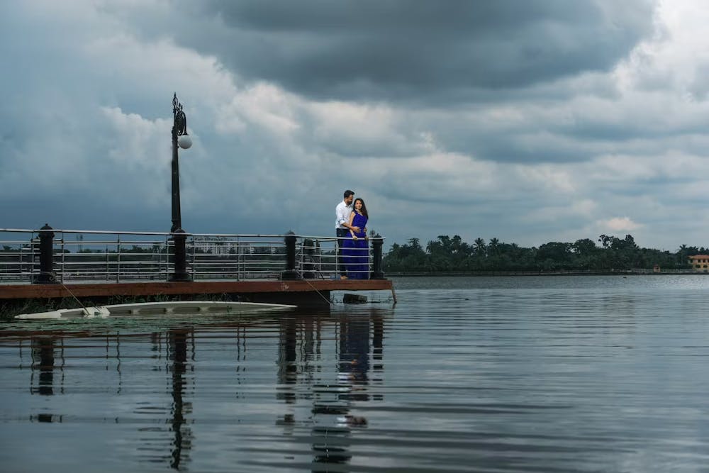 Couple standing beside a river pic