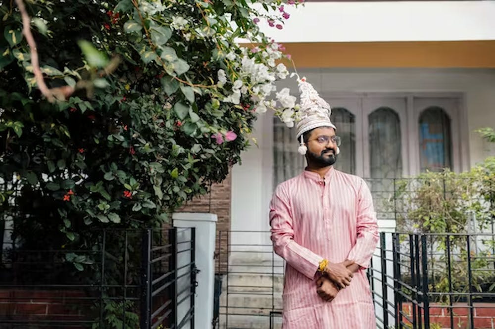 Bengali groom posing with topor on head pic