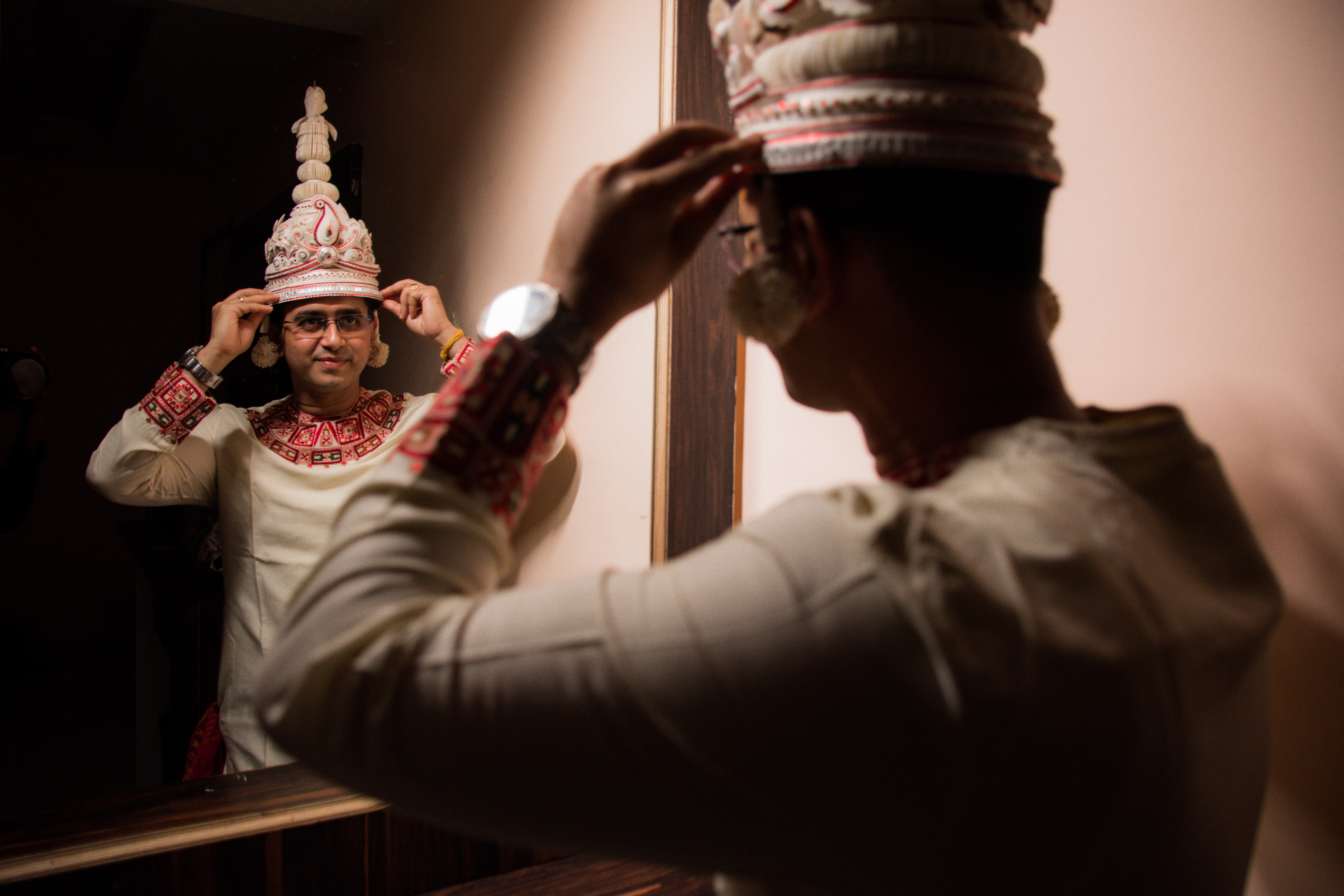 Groom getting ready in front of mirror