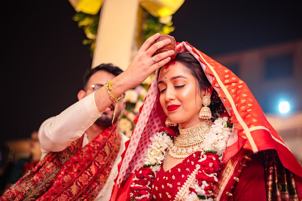 Groom putting vermilion on the forehead of his bride