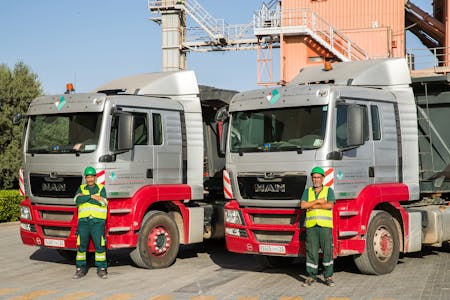 Employés de carrières et transport Ménara devant des camions de la société.