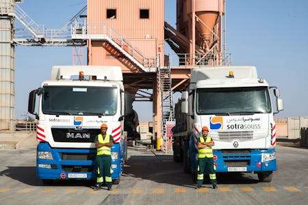 Employés de Sotrassous devant des camions de la société.