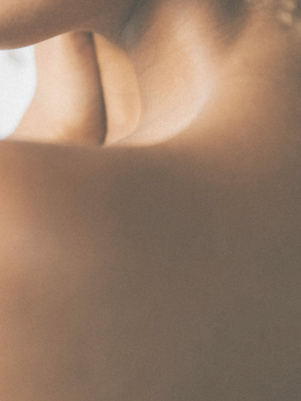 Close up of a woman's side profile focusing on her neck and shoulder