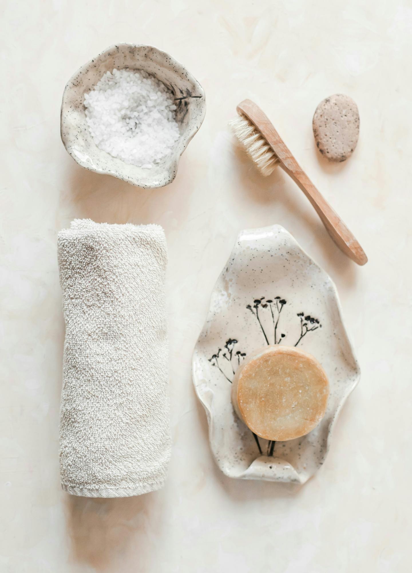 A collection of body tools: towel, salt, body brush, and soap