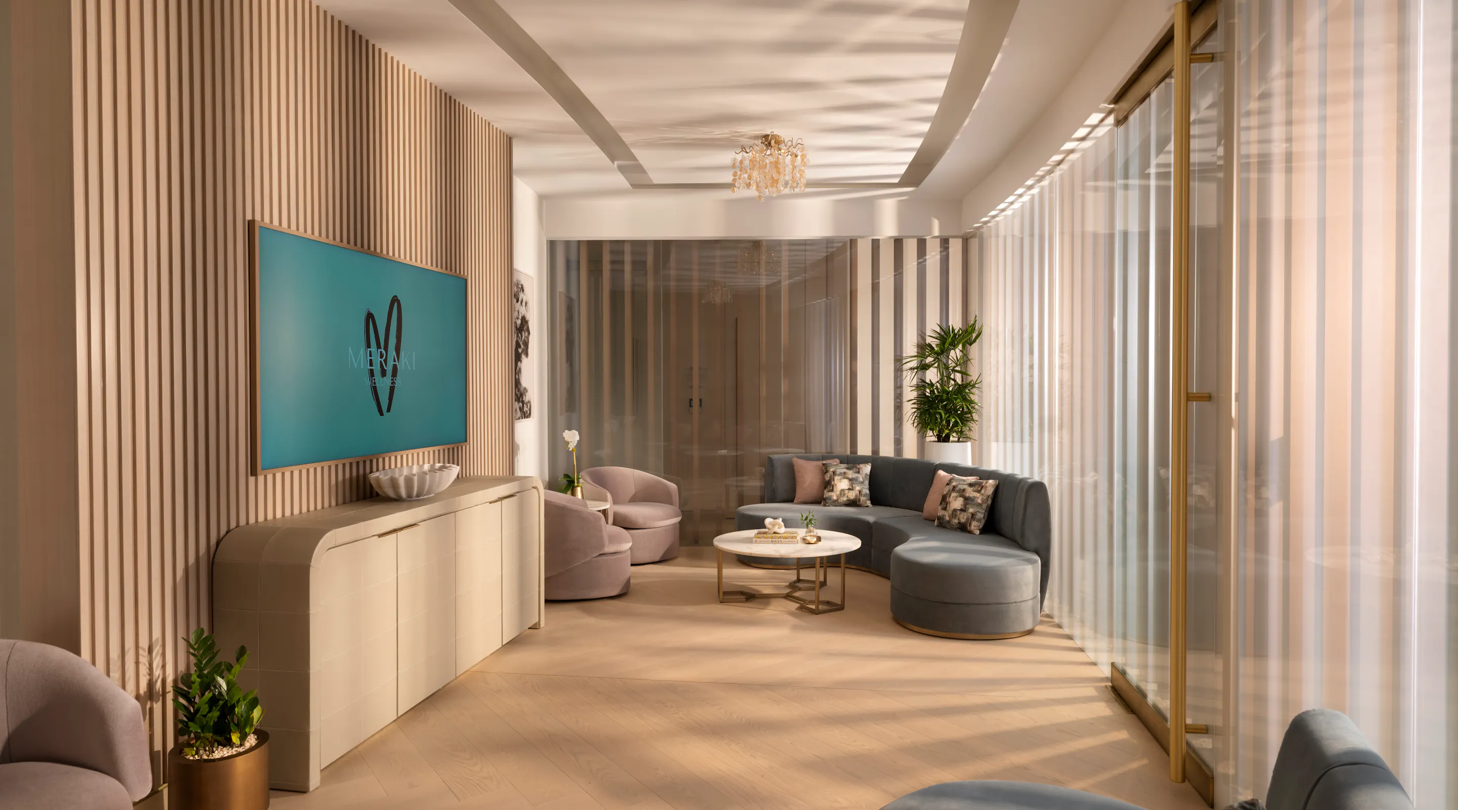 Meraki Wellness Grand Cayman Event Lounge with curved sofas and a TV screen