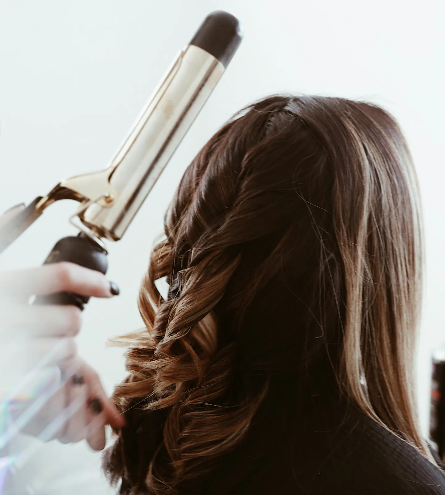 Female having her hair curled with a curling wand