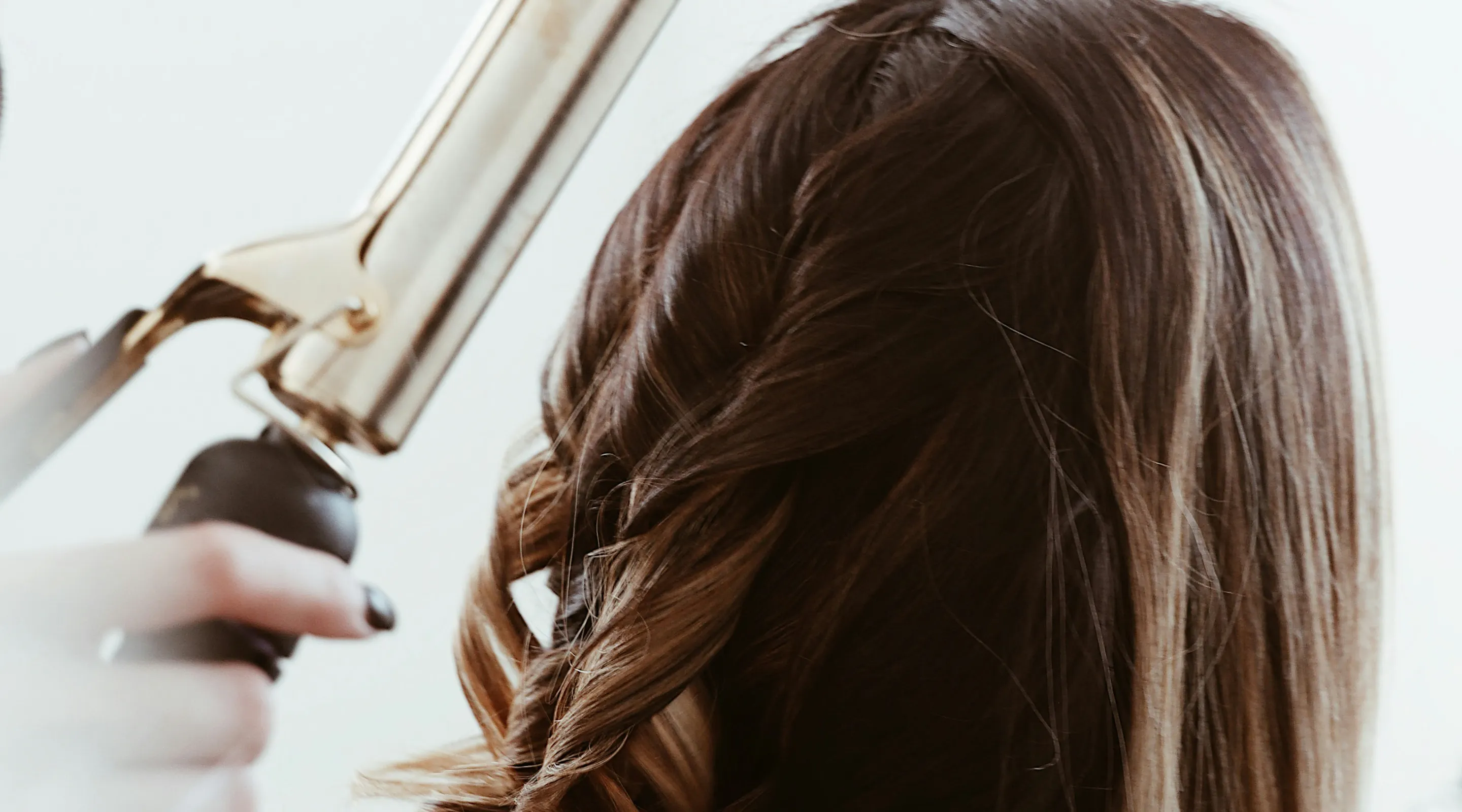 Female having her hair curled with a curling wand