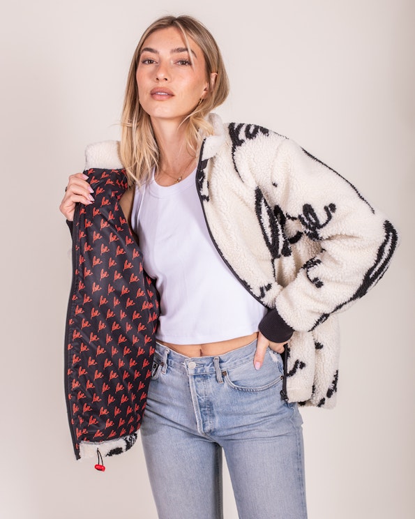 Full custom black and white sherpa fleece jacket with "love" script lining and cherry zipper, produced by MerchCamp for Ruben Rojas