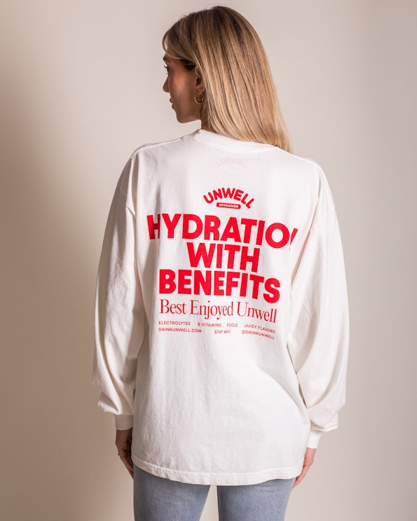 Screen printed white cotton long sleeve tee with bold red typographic back design, produced by MerchCamp for UNWELL