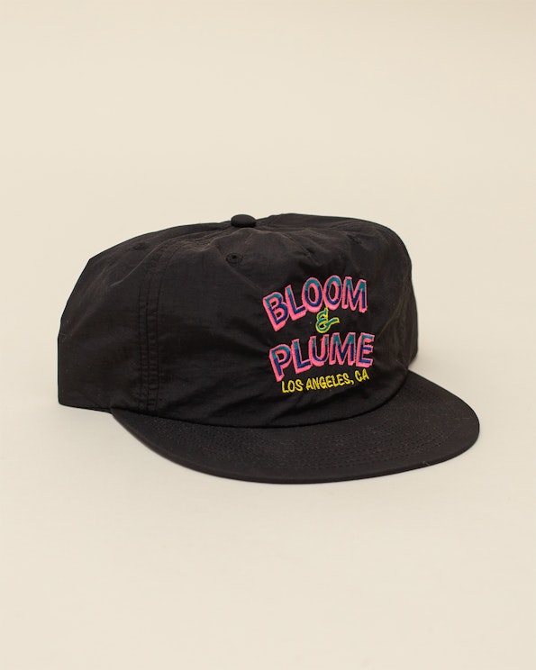 Embroidered black nylon surf hat with pink and yellow retro text graphic, produced by MerchCamp for Bloom & Plume