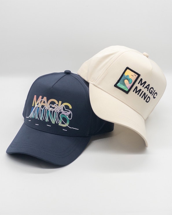 Full custom navy and cream performance snapbacks with embroidered wave graphics and woven patch, produced by MerchCamp for Magic Mind