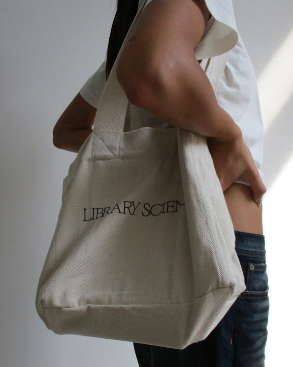 Printed natural canvas tote bag with black serif "Library Science" text, produced by MerchCamp for Community Member