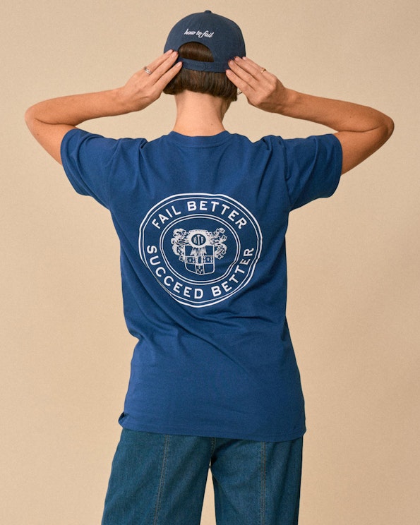 Screen printed navy blue cotton tee with white collegiate crest and motto graphic, produced by MerchCamp for How To Fail Podcast