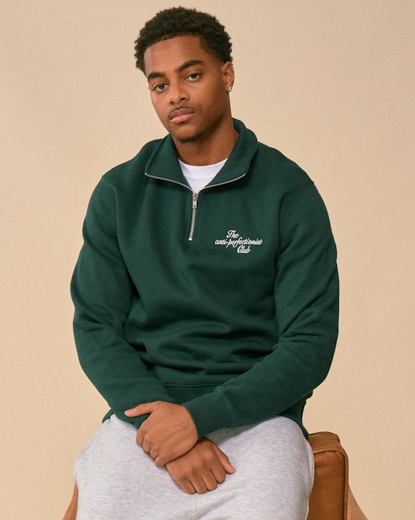 Custom dark green fleece quarterzip sweatshirt with white cursive chest lettering, produced by MerchCamp for How To Fail Podcast