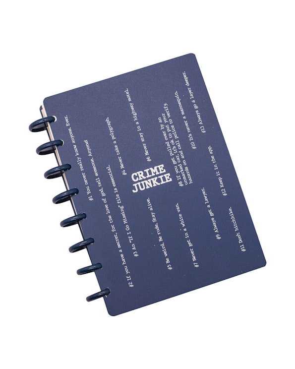 Custom navy disc-bound daily planner with white typographic rules and Crime Junkie branding, produced by MerchCamp for Audiochuck